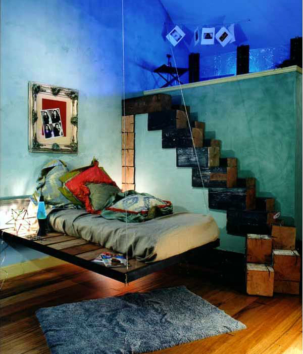 A showcase teenage girls room using large beam sections as stairs up to a loft, paper bags on collage walls and a reuse steel swing bed. Interior design by Carolyn Robbins