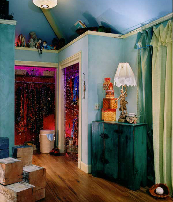 A showcase teenage girls room using large beam sections as stairs up to a loft, paper bags on collage walls and a reuse steel swing bed. Interior design by Carolyn Robbins