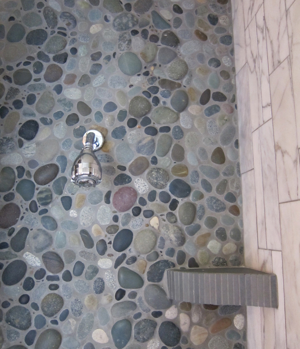 Reconstructed bathroom using river stones and reuse tiles. Marine Green Interior designed by Carolyn Robbins