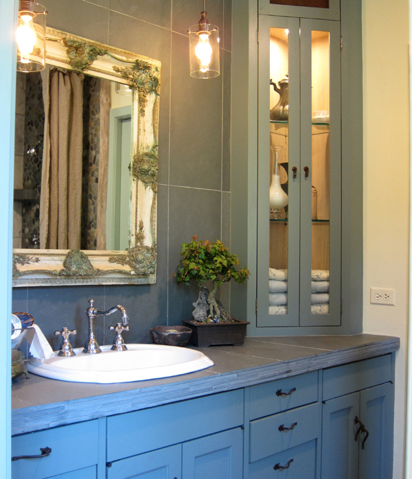 Reconstructed bathroom using river stones and reuse tiles. Marine Green Interior designed by Carolyn Robbins