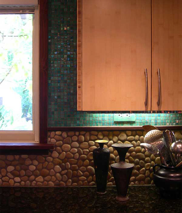 Noted kitchen interior blending sustainable bamboo, river rock, reflective dark granite and aqua glass tile for Japanese inspired seaside interior designed by Carolyn Robbins