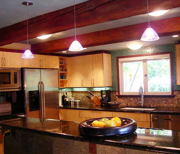 Noted kitchen interior blending sustainable bamboo, river rock, reflective dark granite and aqua glass tile for Japanese inspired seaside interior designed by Carolyn Robbins