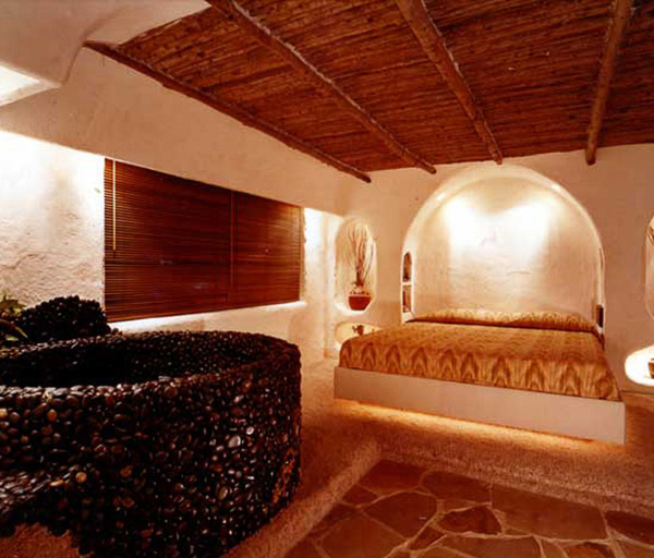 urton Goldberg’s penthouse interior in plaster arched ceilings and cave like alcoves, illuminates his primitive art collection interior design by Carolyn Robbins