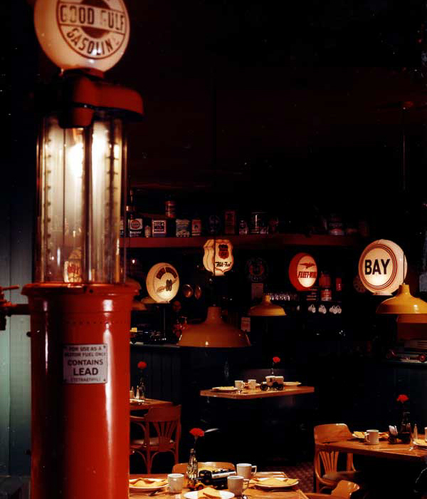 Whitney’s auto-style interior by Carolyn Robbins, features refurbished gasoline pumps, repurposed car-parts and garage pendent lighting.